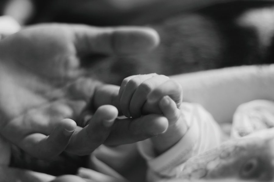 Baby holding parent's finger